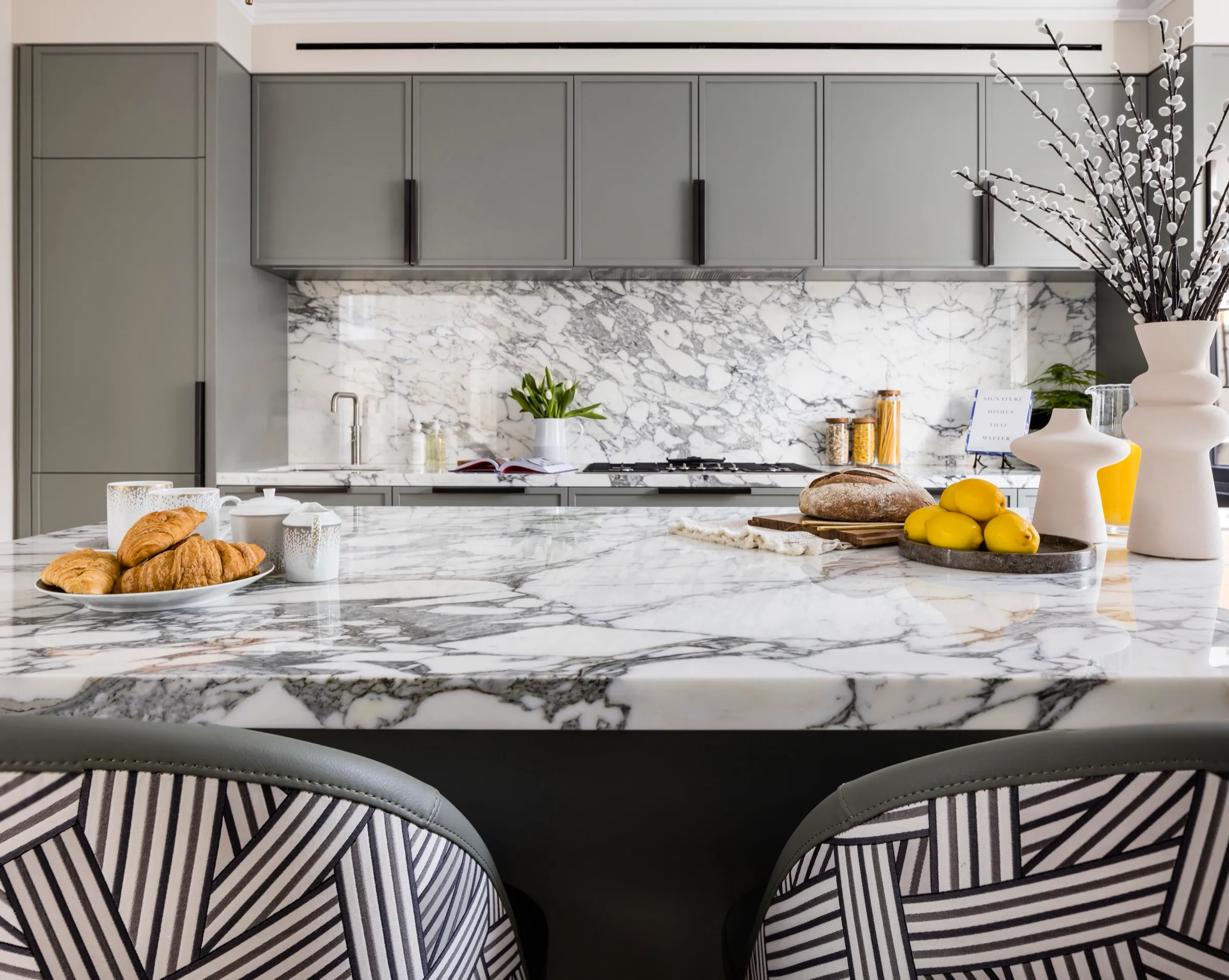 Kitchen with a marble island and grey cabinetry